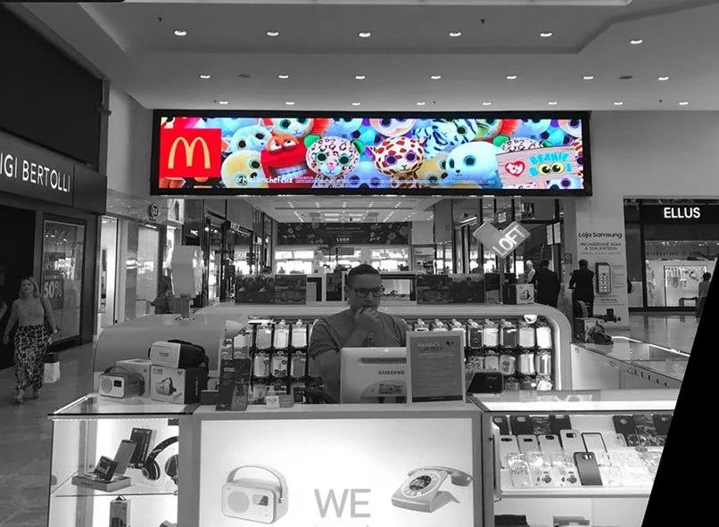 Painel de LED exibindo anúncio em corredor de shopping